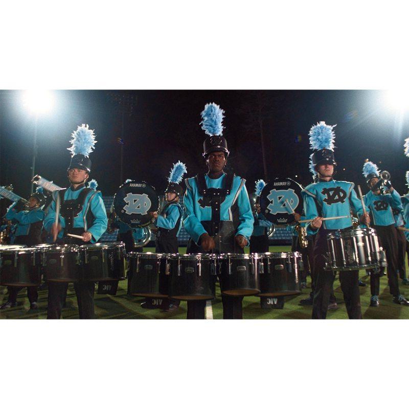 Torin Simpson and other members of the Marching Tar Heels band in uniform and performing.